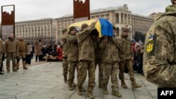 Українські воїни несуть труну з Русланом Ганущаком (позивні "Фотограф" і "Остап"). Церемонія поховання українського військовослужбовця, журналіста, фотографа на Майдані Незалежності в Києві 18 січня 2025 року. Фото: Tetiana DZHAFAROVA/AFP