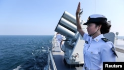 资料照:中国海军女兵在中俄海军在广东湛江举行的联合海军演习结束时向俄罗斯军人挥手致意。(2016年9月19日)