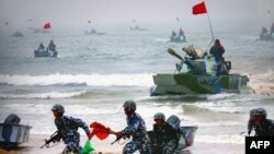 资料照片:官方公布的图像显示,中国两栖坦克与士兵参加在山东举行的登陆军演。(2005年8月24日)