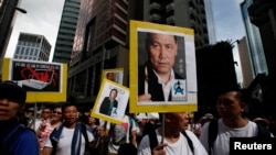 香港民众举着浦志强和高瑜的肖像游行示威(2014年7月1日)