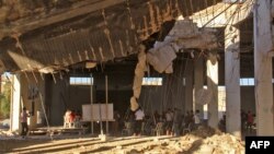 Syrians gather in a destroyed building in Khan Sheikhun, a rebel-held town in the northwestern Idlib province, on July 12, 2017, 100 days following a suspected toxic gas attack.