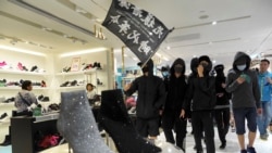 香港黑衣抗议者在铜锣湾的一个商场里举“光复香港,时代革命”的旗子示威。(美联社2019年12月26日)