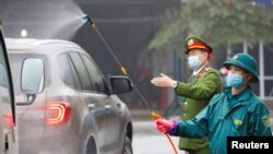 越南防疫官员为防范新冠病毒疫情给车辆喷洒消毒药水。(2020年2月7日)