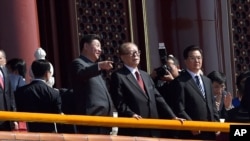 在“纪念中国人民抗日战争暨世界反法西斯战争胜利70周年”阅兵时,中国主席习近平和前主席江泽民交谈。胡锦涛在旁边(2015年9月3日)