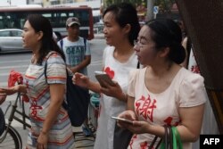 709案维权律师谢阳的妻子陈桂秋,唐荊陵的妻子王艳芳, 勾洪国(网名戈平)的妻子樊丽丽在最高法院外面,她们的衣服上印有丈夫的名字(2016年7月4日)