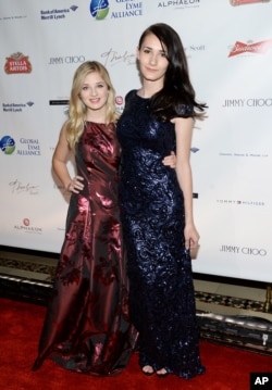 歌手杰基·伊万科( Jackie Evancho, 左)和她的变性人姐姐朱丽叶·伊万科(Juliet Evancho) 在纽约参加慈善团体全球莱姆联盟主办的晚会(2015年10月8日)
