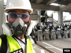 美国之音记者在香港机场报道香港反中民众机场示威防暴警察清场的实况。(美国之音记者黎堡拍摄)