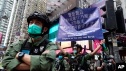 在中国共产党建立政权周年纪念日,一名警察在香港铜锣湾打出警告旗。(2020年10月1日)