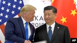 美国总统特朗普(左)在日本西部大阪举行的G20峰会期间与中国国家主席习近平握手(2019年6月29日)。