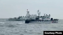 台湾海巡署一艘巡防艇(前)在金门附近限制水域与一艘中国海警船併航并进行广播驱离。(2024年12月27日,台湾海巡署提供)