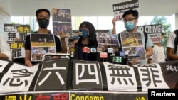 香港支联会副主席邹幸彤(中)在被指控纪念六四事件为非法组织集会后对媒体讲话。(2021年6月11日)