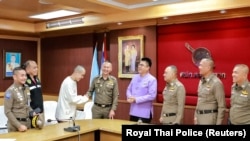 在泰缅边境附近遭电诈集团绑架的中国演员王星被泰国警方找回后与泰国警官握手。(2025年1月7日 )