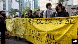 资料照:香港民众举着横幅在法庭外,为在新国安法下被拘留的47名活动人士表示支持。 (美联社2021年3月1日拍摄)