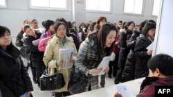 资料照:中国数名青年妇女在北京的一个招聘会上排队寻找工作。(2010年3月3日)