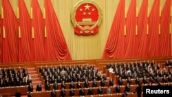 资料照:在北京人大会堂参加全国人大会议的中国官员起立唱国歌。(2019年3月15日)