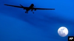 FILE - In this Jan. 31, 2010, photo, an unmanned U.S. Predator drone flies over Kandahar Air Field, southern Afghanistan, on a moonlit night.