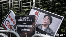 资料照:香港抗议者在北京驻香港机构中联办前手举铜锣湾书店失踪老板桂民海的照片。 (2016年1月19日)
