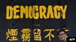 一名香港民主派抗议者站在横幅前。(2014年9月30日资料照)