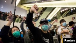 2月15日,香港一个购物中心里,港人与大陆游客发生摩擦。抗议者向陆客作出手势,表示不满。