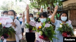 缅甸妇女在仰光手捧鲜花参加反对军事政变的抗议活动。(2021年4月13日)