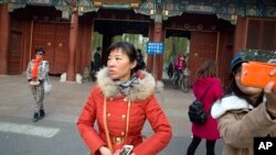 游人在北京大学入口拍照留念(2014年11月20日资料照)