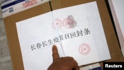 中国长春疾病控制中心的工作人员在召回的长春长生公司生产的狂犬病疫苗箱子上贴封条。(2018年7