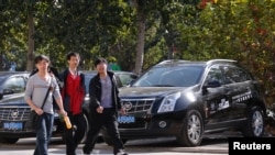 年轻人走过北京城外一家卡迪拉克车行。(2012年10月31日)