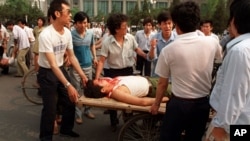 1989年6月4日,在解放军士兵向人群开火后不久,当地居民将伤员抬上了一辆人力平板车。