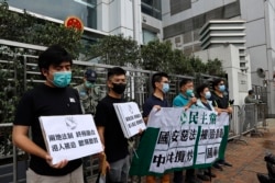 香港民主党成员在中联办门口手举标语抗议“港版国安法”。(2020年5月22日)