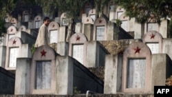 一位中国民众行走在1979年中越战争阵亡将士墓园中。(2007年2月22日)