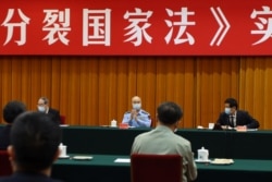 中国全国人大委员长栗战书(右)中央军委副主席许其亮(中)在北京出席“反分裂国家法”会议。(2020年5月29日)