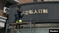 上海一名工人移走商店招牌上的“韩国”两字(2017年3月15日照片)