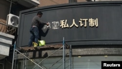 上海一名工人移走商店招牌上的“韩国”两字(2017年3月15日照片)