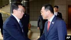 韩国代表团团长金奎显(右)在板门店与朝鲜代表团团长元东渊握手(2012年2月12日)