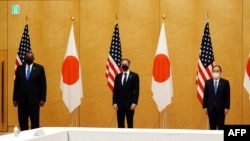 美国国务卿布林肯(中)和美防长奥斯汀(左)在东京与日本首相菅义伟合影。(2021年3月16日)