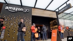 人们站在亚马逊公司在西雅图开办的由人工智能驱动的线下实体商店Amazon Go的门外。(2018年1月22日)