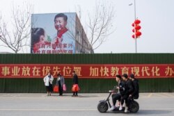 中国河南省一所学校旁树立的习近平画像与标语。(2019年2月22日)