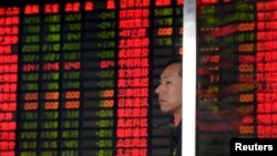 一名股民在上海一家交易所的电子屏幕前观看股市行情。(2015年9月2日)