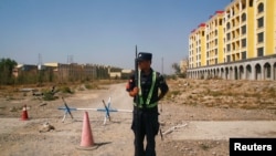 资料照片:中国警察在新疆伊宁一处官方所说的职业教培中心附近的路口站岗。(2018年9月4日)