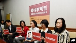 台湾人权活动人士李明哲的妻子李净瑜在台北的记者会上手持李明哲的照片,非政府组织的代表们也参加了记者会(2017年3月24日)
