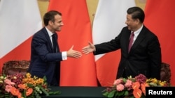 法国总统马克龙与中国国家主席习近平在北京人大会堂的签约仪式上握手。(2019年11月6日)