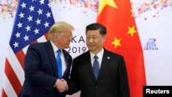 资料照片:时任美国总统唐纳德·特朗普与中国国家主席习近平在日本大阪举行的G20领导人峰会中握手。(2019年6月29日)