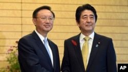 中国国务委员杨洁篪(左)访问日本与日本首相安倍晋三握手。