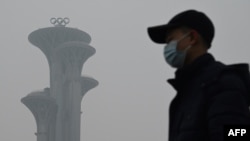 一名男子在雾霾天走在北京奥林匹克公园里。(2022年1月24日)