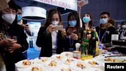 在上海参观中国国际进口博览会上的观展者给澳大利亚龙虾拍照。(2020年11月6日)