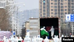 身穿防护服的工人在清理清理武汉华南海鲜市场。这里曾被认为是新冠病毒的发源地。(2020年3月4日)