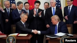 资料照片:特朗普在他第一总统任期内和时任中国副总理刘鹤在白宫签署美中第一阶段经贸协议。(2020年1月15日)