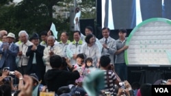 蔡英文竞选总部成立大会,小朋友上台送上募款小猪 (美国之音李逸华拍摄)