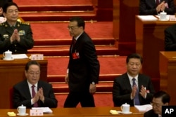在人大会议开幕式上,中国总理李克强在中国主席习近平身边走过,上台做工作报告(2016年3月5日 )