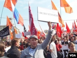 在2012年5月6日普京就职总统前的莫斯科大规模反政府示威上,一名抗议者手举标语,“普京是非法总统”(美国之音白桦拍摄)